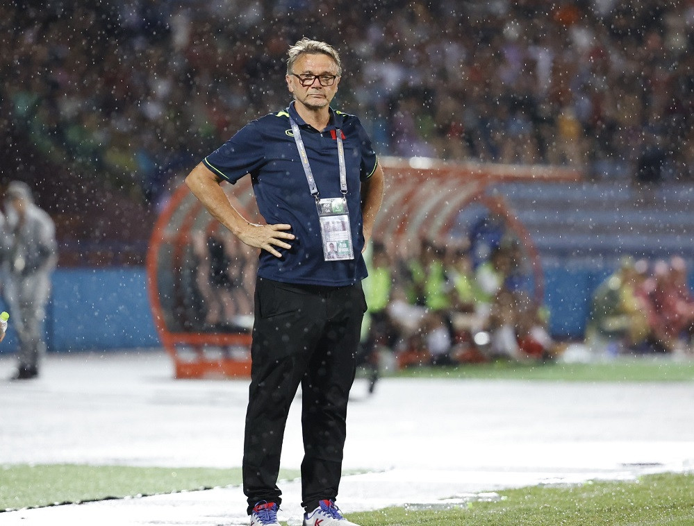 HLV Troussier đội mưa chỉ đạo học trò. Ảnh: Như Ý