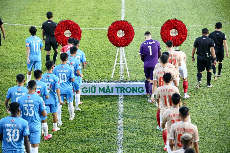 Các cầu thủ cúi đầu khi bước qua các vòng hoa. Ảnh: Dư Hải