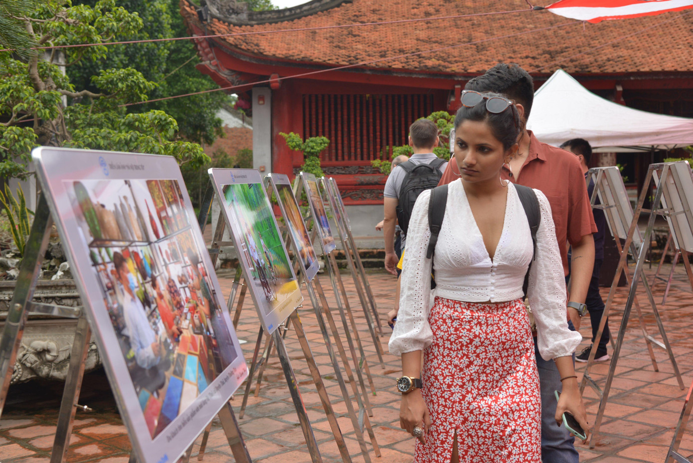 Khách du lịch dừng lại xem tác phẩm nhiếp ảnh mừng Giải phóng Thủ đô. Ảnh: LẠI TẤN.