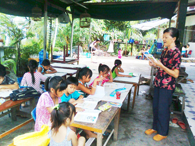 Bà Năm dạy lớp hai… Học sinh của bà Năm là con em của những người nghèo khó. Ảnh: Nguyên Anh
