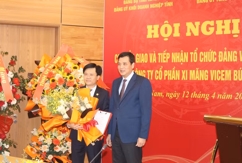 Đồng chí Bùi Xuân Dũng, Bí thư Đảng ủy, Chủ tịch HĐTV VICEM trao quyết định tiếp nhận tổ chức đảng và đảng viên cho đồng chí Đỗ Tiến Trình, Bí thư Đảng ủy, Tổng giám đốc VICEM Bút Sơn.