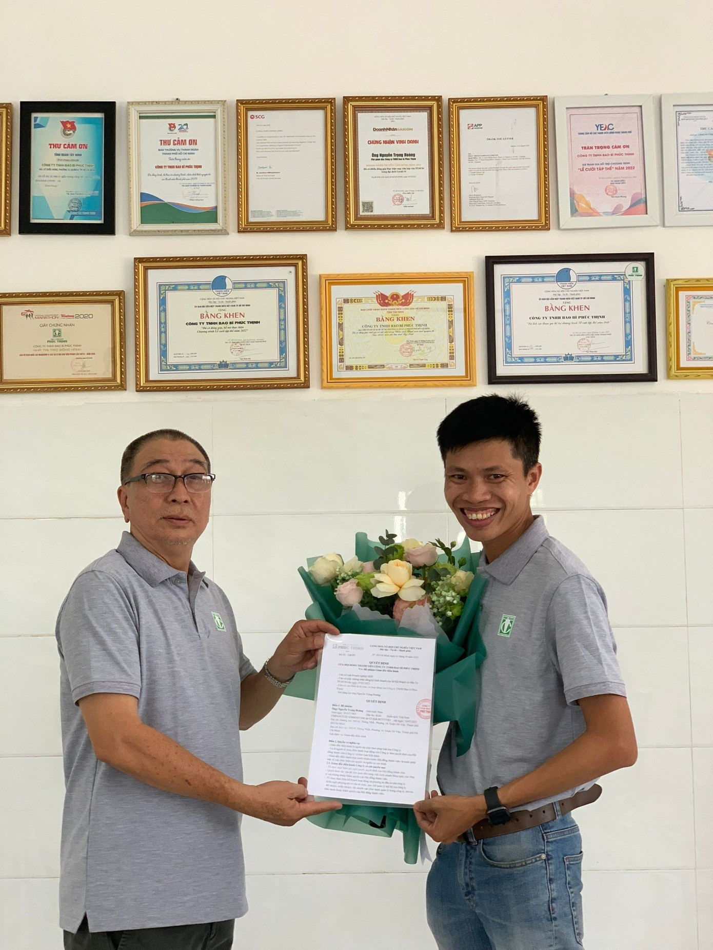 Ông Nguyễn Trọng Hoàng( bên phải) nhận quyết định từ ông Lưu Văn Cường- Chủ tịch HĐTV- Tổng giám đốc công ty TNHH bao bì Phúc Thịnh.