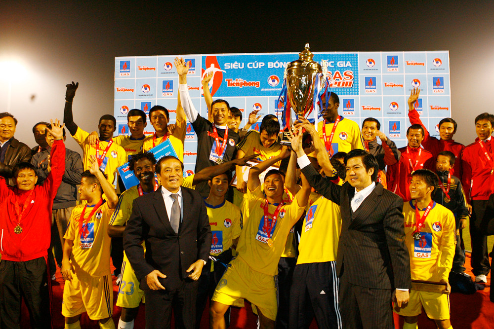 Ông Đoàn Công Huynh - Tổng Biên tập báo Tiền Phong và ông Nguyễn Trọng Hỷ - Chủ tịch Liên đoàng Bóng đá Việt Nam trao cúp cho đội SLNA. Ảnh: Hồng Vĩnh