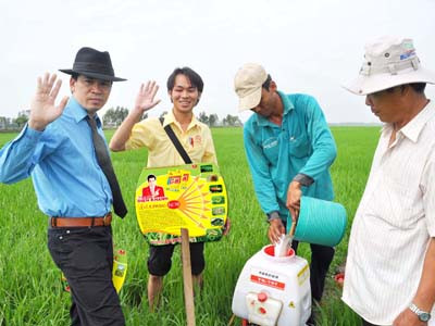 Nguyễn Thanh Lang (bìa trái) trên cánh đồng cùng nông dân