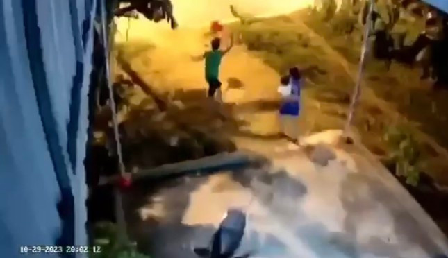 Cháu bé bị người bố túm chân quăng ra xa. Ảnh cắt từ clip.