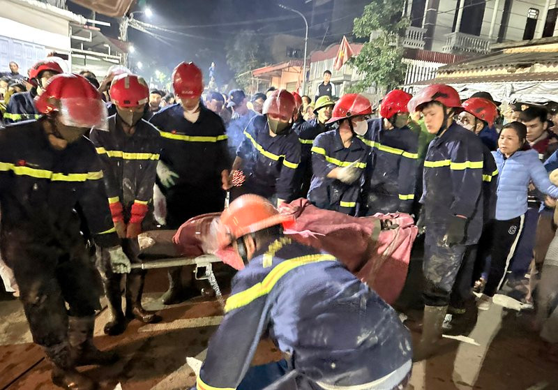 Lực lượng chức năng đưa thi thể nạn nhân ra ngoài.