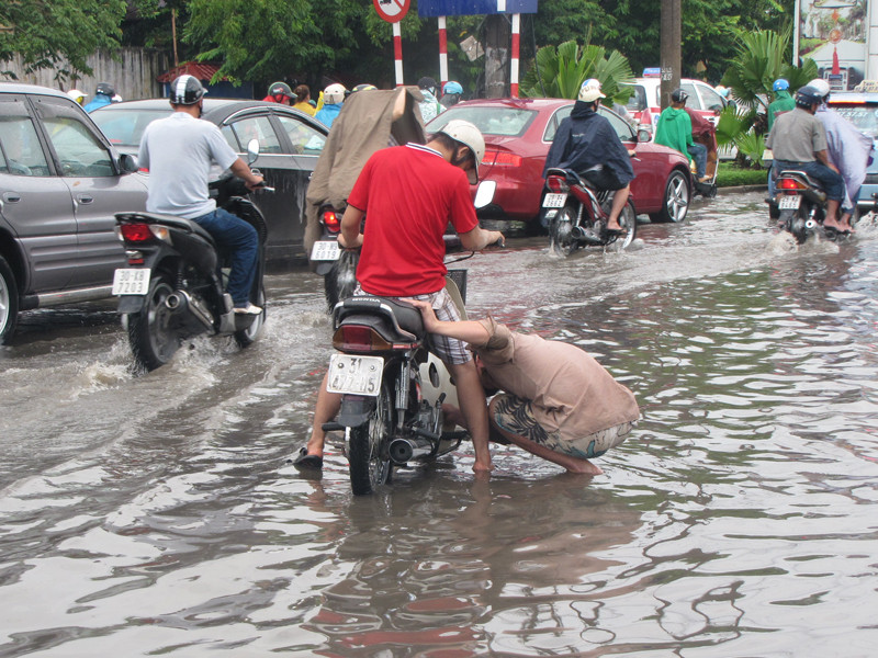 Một nam thanh niên dùng miệng thổi khô Buzi trên đường Kim Liên. Ảnh: Trường Phong