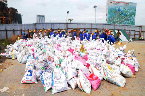 Hàng chục công nhân được huy động để xúc cát vào các bao tải, dựng tường bao bảo vệ, tránh các đợt mưa bão tiếp theo ảnh hưởng tới quá trình thi công