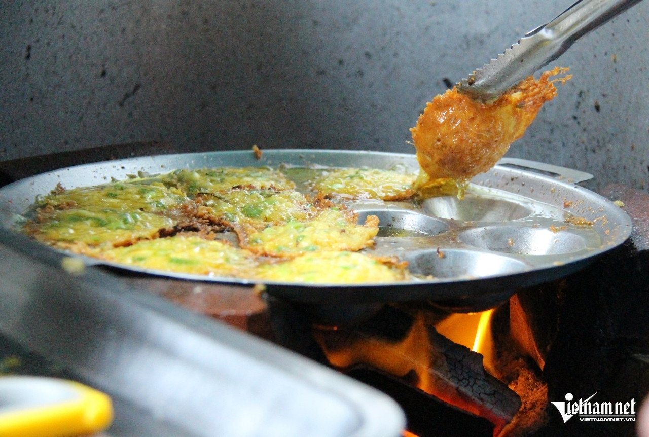 Bà chiên bánh bằng bếp than, luôn giữ nhiệt độ ổn định để bánh chín, giòn đều. Ảnh: Hà Nguyễn