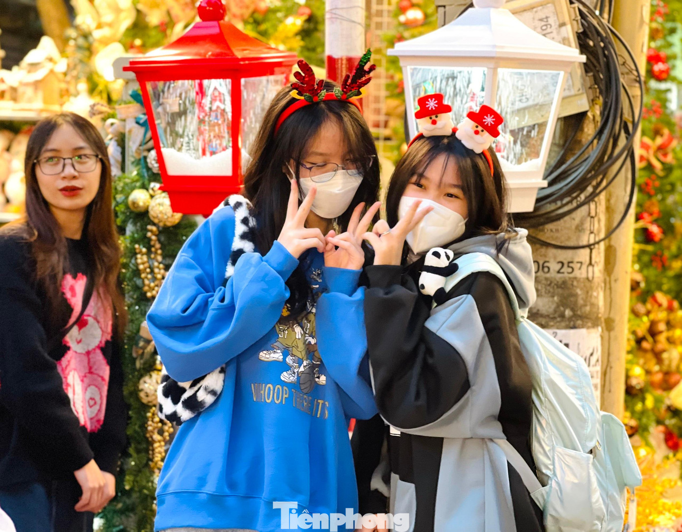 Các bạn trẻ thích thú tạo dáng bên cột đèn điện có tuyết rơi, mẫu trang trí Noel bắt mắt tại phố Hàng Mã.