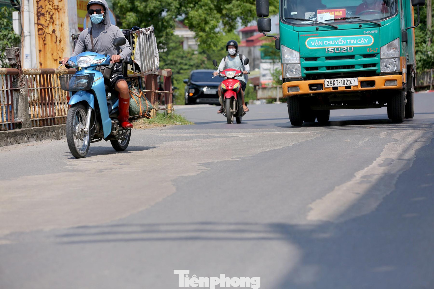 Mặt đường đầy vết vá chằng chịt sau nhiều lần sửa chữa.