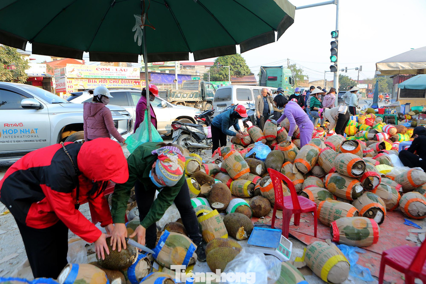 Tại ngã tư Phai Trần trên quốc lộ 1A đoạn đi qua thành phố Lạng Sơn, nhiều xe container đã dỡ hàng tấn mít chất đầy trong thùng xe xuống để bán cho khách dọc đường.