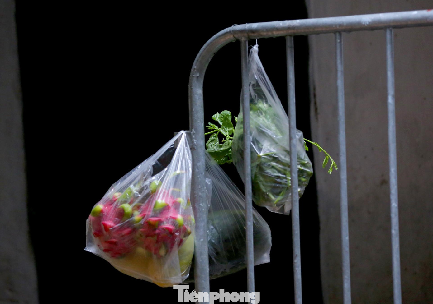 Đồ tiếp tế đươc treo tại rào chắn để phun khử khuẩn trước khi chuyển vào cho các căn hộ bên trong ngõ.