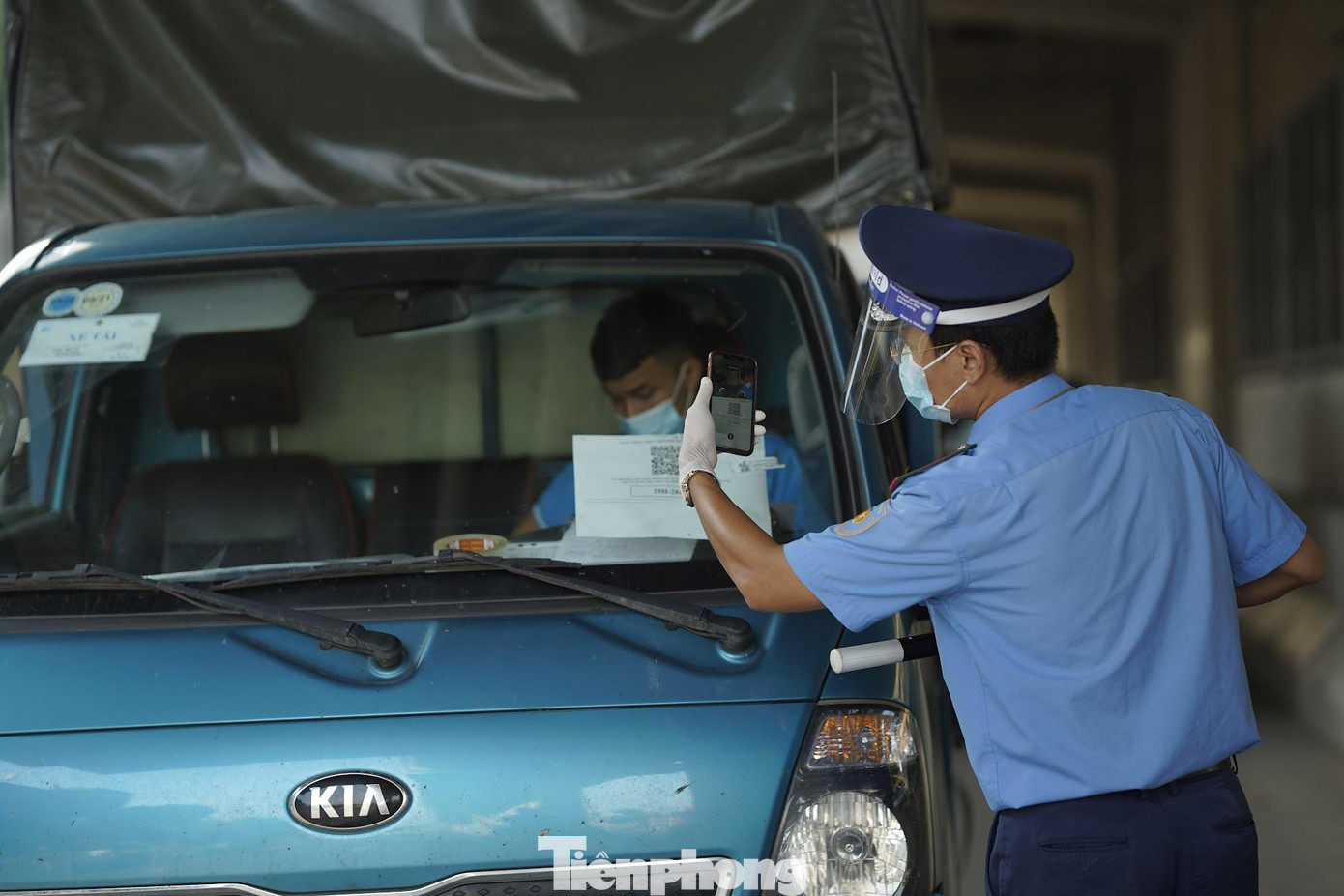 Phía làn ô tô, lực lượng CSGT, CSCĐ và TTGT vận tải kiểm tra giấy tờ, đồng thời quét mã QR. Với những xe tải có giấy nhận diện luồng xanh đúng quy định sẽ được lưu thông qua chốt. .