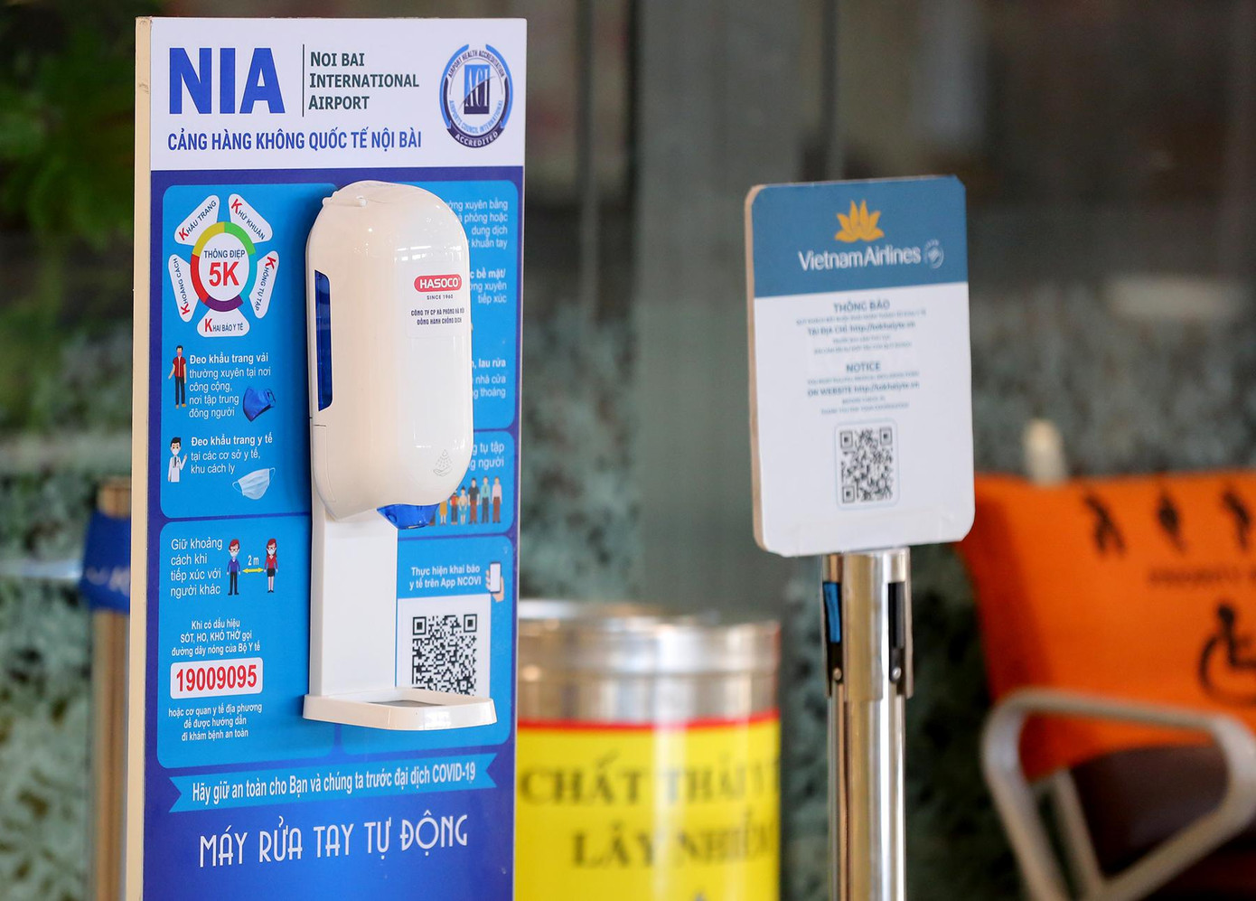 Bảng hướng dẫn thông điệp 5K, mã QR khai báo y tế và nước rửa tay sát khuẩn được đặt tại nhiều điểm trong sảnh đến của sân bay Nội Bài.