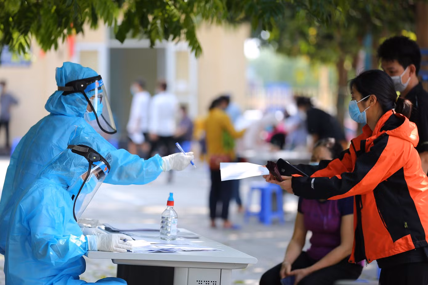 Những người dân đến lấy mẫu xét nghiệm đều được đo thân nhiệt và rửa tay sát khuẩn.
