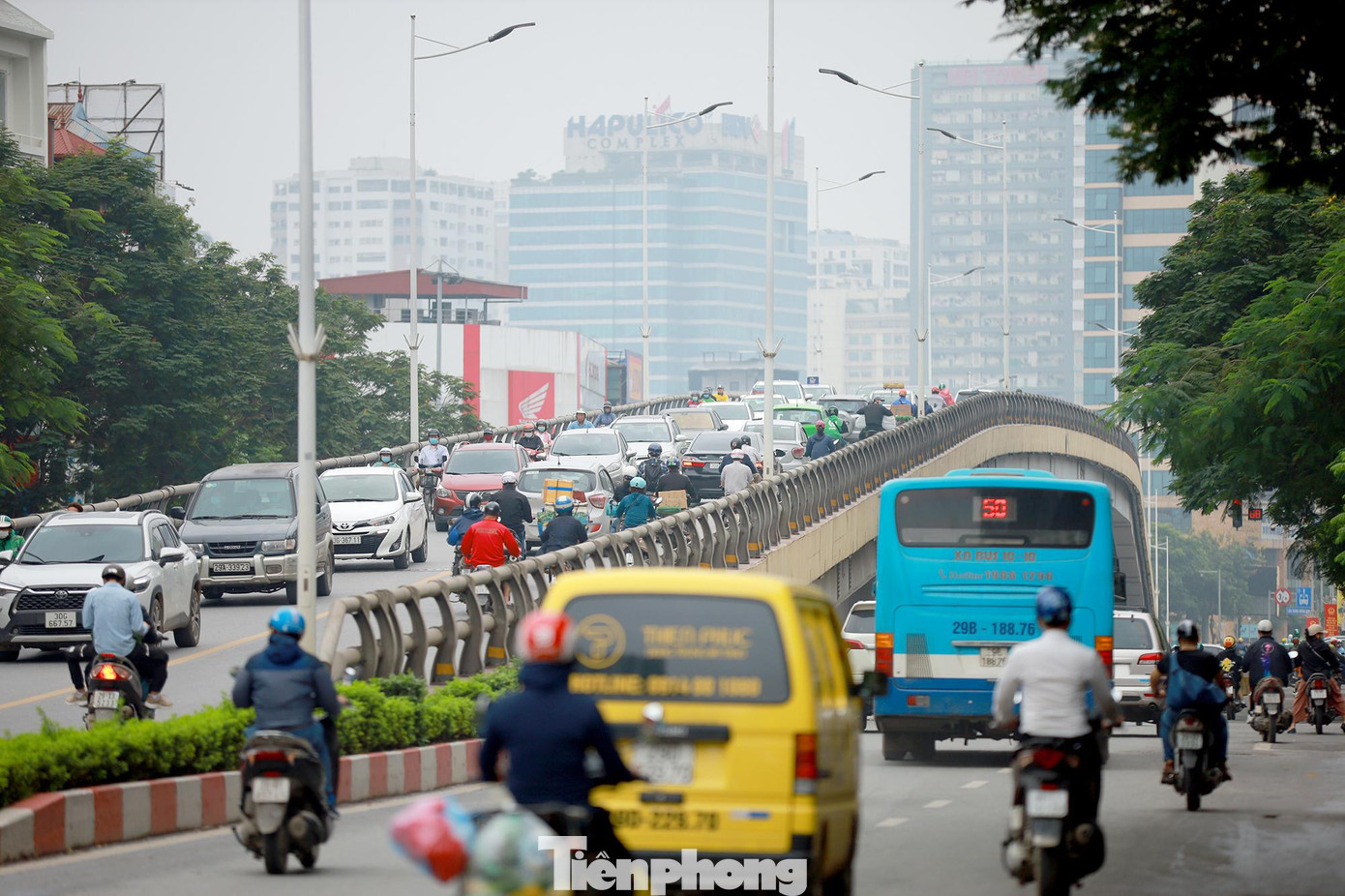 Xe máy nối đuôi nhau đi lên cầu vượt trong giờ cao điểm sáng 28/04.