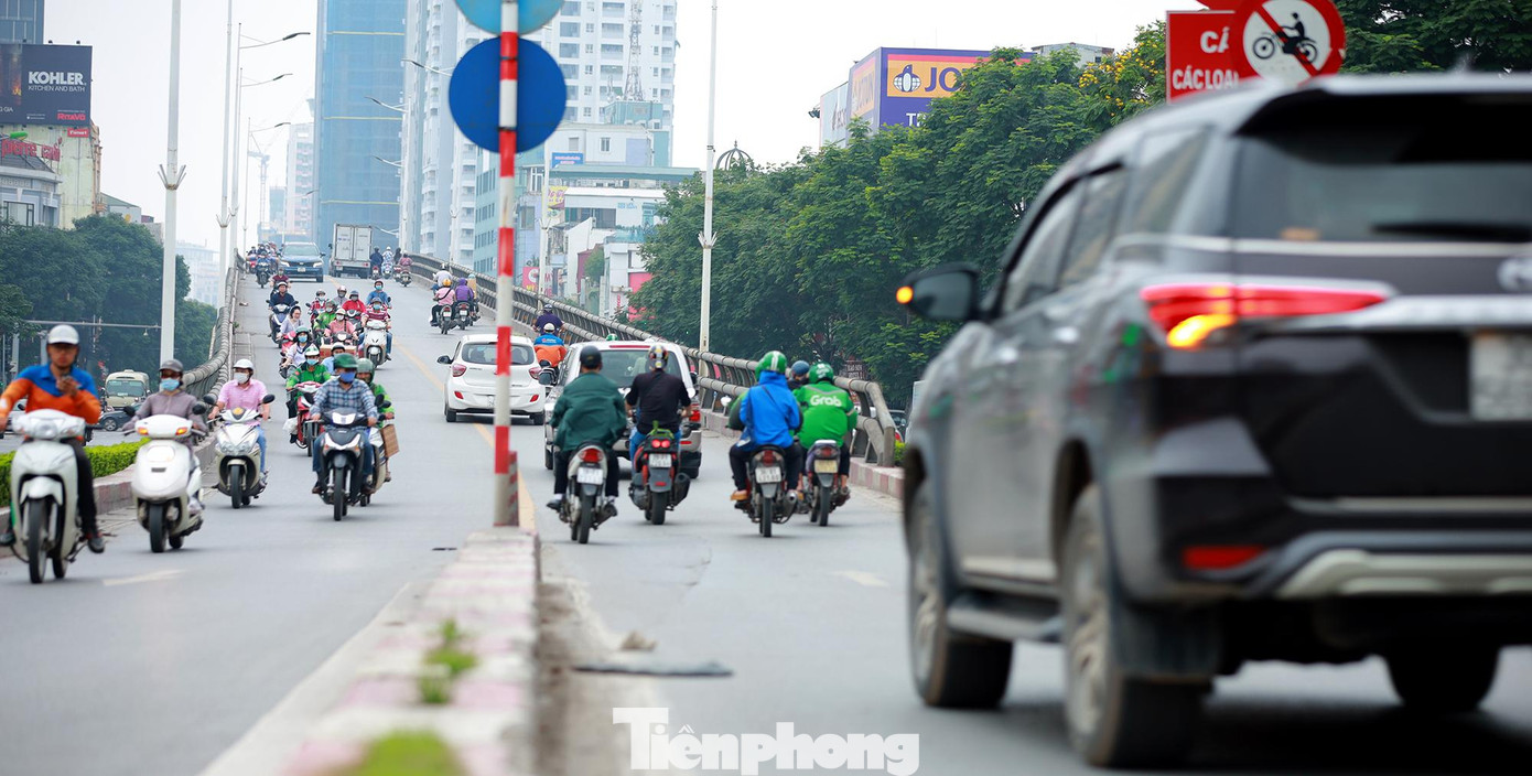 Xe máy nối đuôi nhau đi lên cầu theo cả hai hướng.