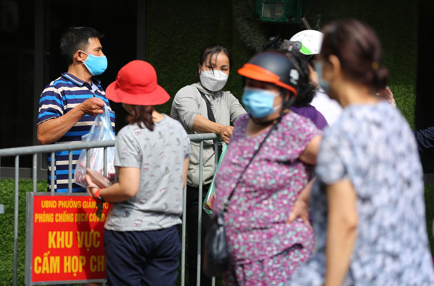 Người dân chuyển sang mua bán qua hàng rào chắn của lực lượng chức năng.