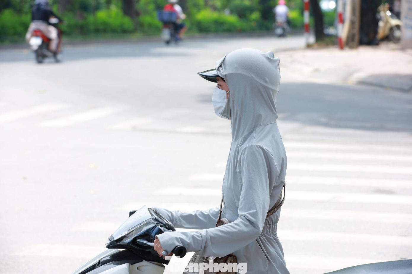 Trang phục chống nắng, khẩu trang kín mặt là những vật dụng không thể thiếu của người dân mỗi khi ra ngoài đường.