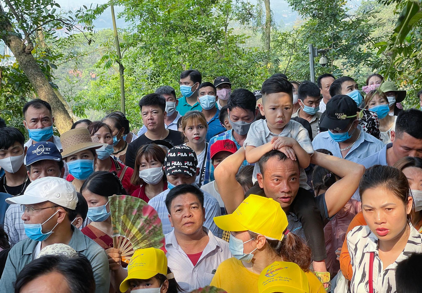 Em nhỏ được bố kiệu lên cổ theo dòng người lên đền Hạ.