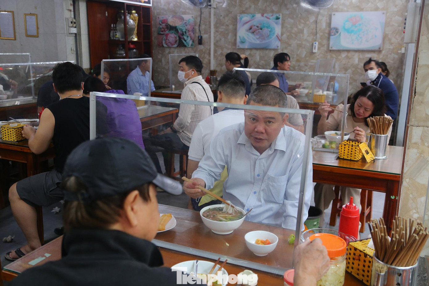 Khách được bố trí giữ khoảng cách, các bàn đều được trang bị tấm chắn đảm bảo an toàn cho mọi người.