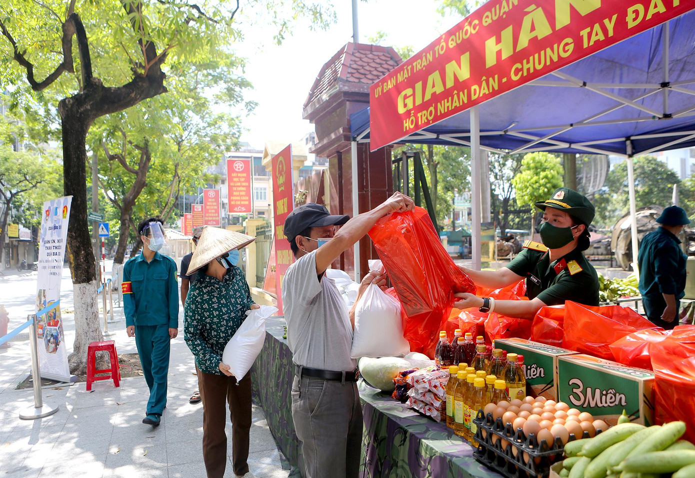 Người dân xếp hãng đảm bảo giãn cách tối thiểu 2 m để nhận quà tặng từ gian hàng 0 đồng.