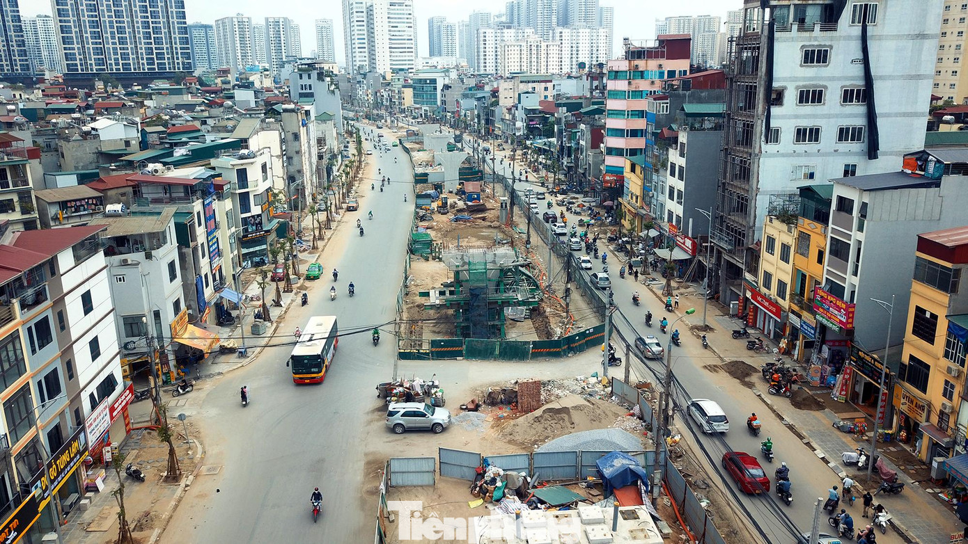 Hai làn đường vành đai 2 dưới thấp đang hiện rõ từng ngày, hai bên vỉa hè đang được thi công lát đá khẩn trương Hình hài con đường đang dần hoàn thiện nhìn từ trên cao.