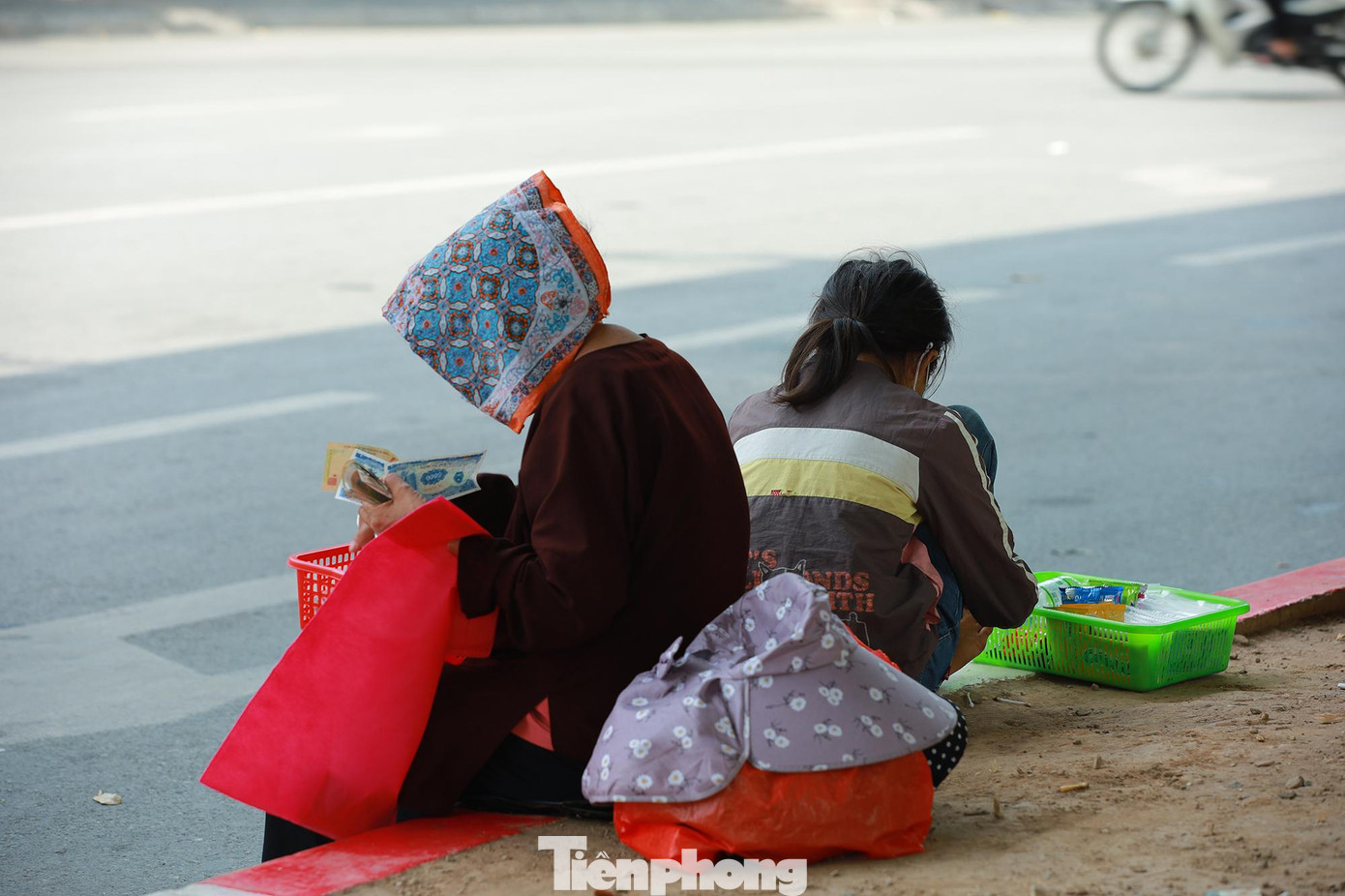 Người dân tranh thủ nghỉ trưa dưới bóng mát của cây cầu vượt với khăn ướt trùm kín đầu để giảm cái nắng hầm hập.