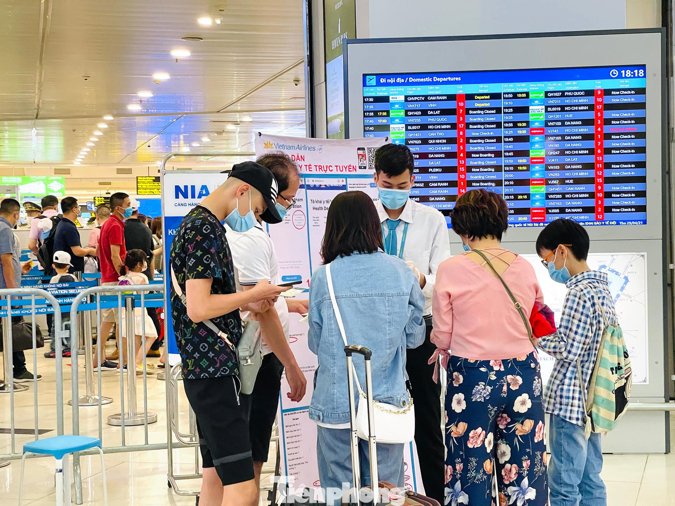 Nhân viên bộ phận mặt đất của sân bay Nội Bài hướng dẫn hành khách làm thủ tục khai báo y tế bắt buộc.