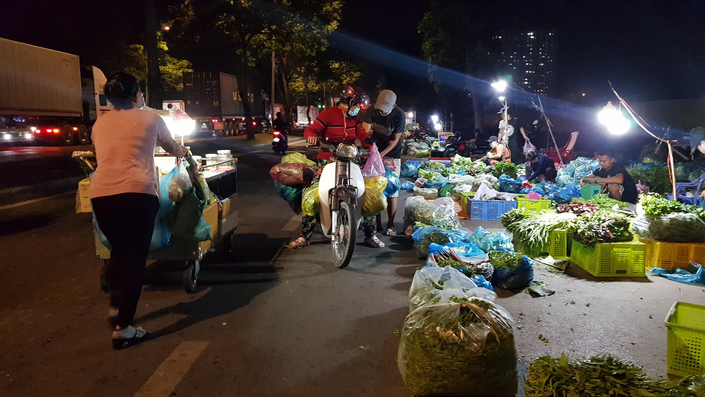 Đường Nguyễn Văn Linh gần cổng chợ Bình Điền trở thành điểm kinh doanh rau củ quả.