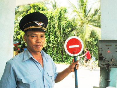 Anh Lợi bên chiếc hộp liên lạc tín hiệu (phải) thay cho bảng xin đường thủ công cầm tay