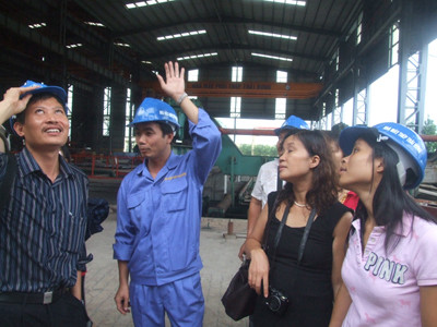 Giám đốc Nhà máy Thái Hưng, Nguyễn Văn Tuấn 32 tuổi (đội mũ, đứng giữa), giải thích với các nhà báo và nhà khoa học về nguồn cội cái đầu ống khói kỳ dị