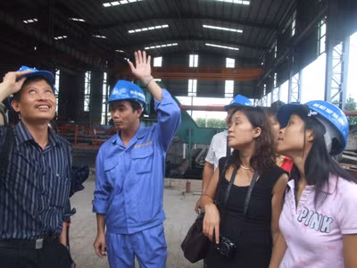 Giám đốc Nhà máy Thái Hưng, Nguyễn Văn Tuấn 32 tuổi (đội mũ, đứng giữa), giải thích với các nhà báo và nhà khoa học về nguồn cội cái đầu ống khói kỳ dị