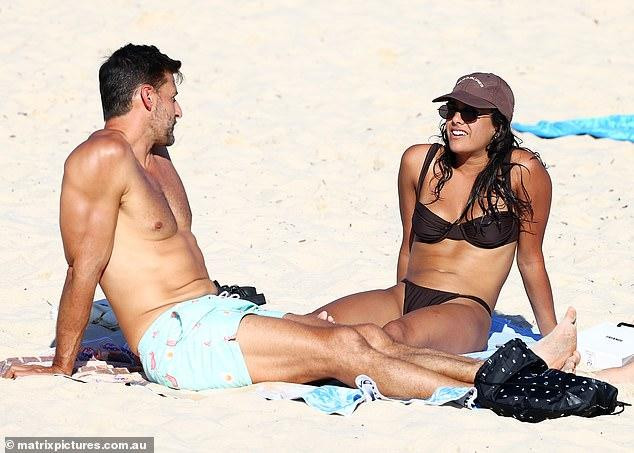 Cặp bạn diễn ngồi trên bãi cát trò chuyện khá thân mật. Không chỉ vậy, khoảng cách ngồi rất gần và bàn chân trái của nữ diễn viên còn chạm hẳn vào đùi của Tim Robards.