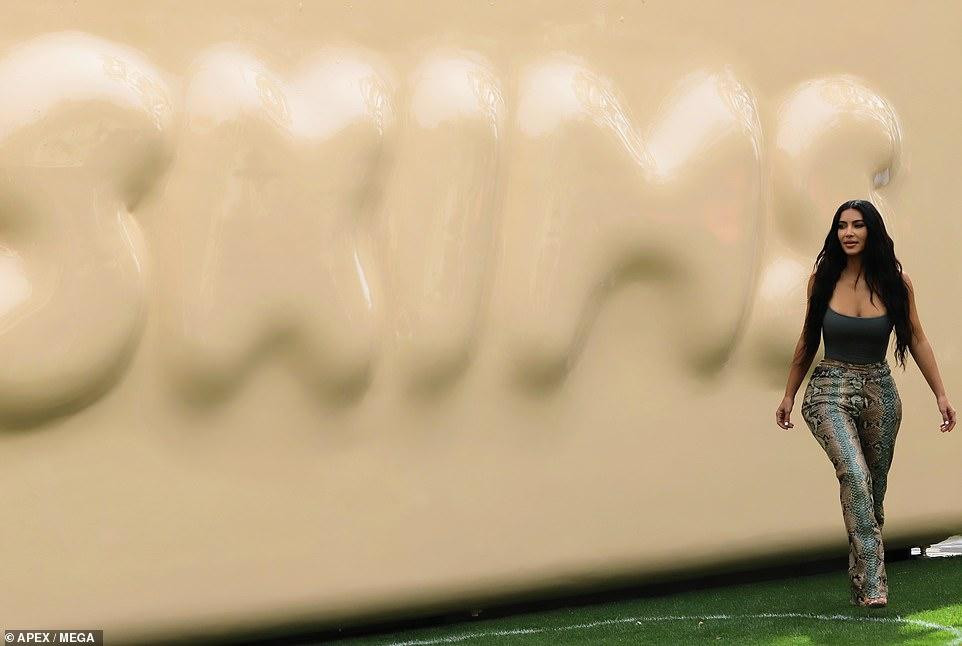 Kim tạo dáng khoe body đồng hồ cát tuyệt đẹp bên tấm backrop in nổi hình thương hiệu SKIMS