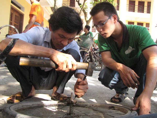 Bác Năng, một phụ huynh học sinh dành cả buổi chiều giúp đỡ các sinh viên tình nguyện sửa xe.