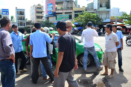 Tranh nhau bấu víu xe Taxi.Ảnh: Việt Hương