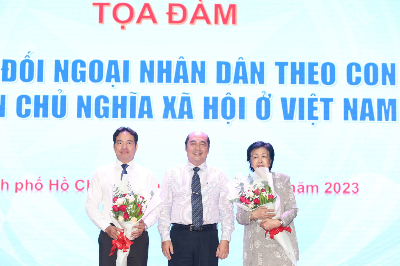 Lãnh đạo HUFO tặng hoa cám ơn những chia sẻ của hai diễn giả tại tọa đàm. Ảnh: Ngô Tùng