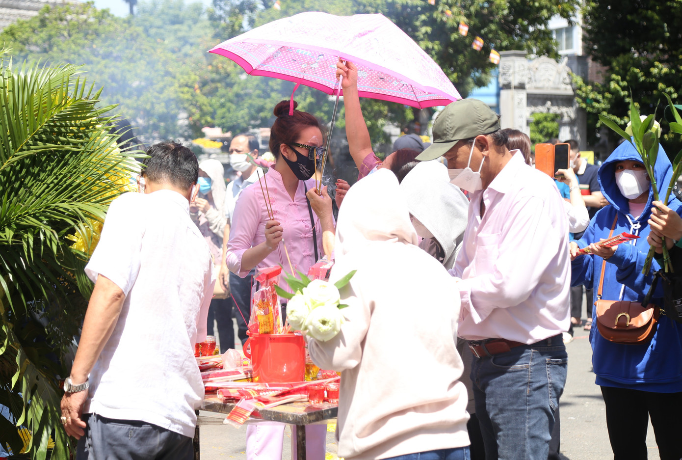 Nhiều người phải mang ô, trùm mũ kín kẽ để tránh cái nắng gay gắt ban trưa.
