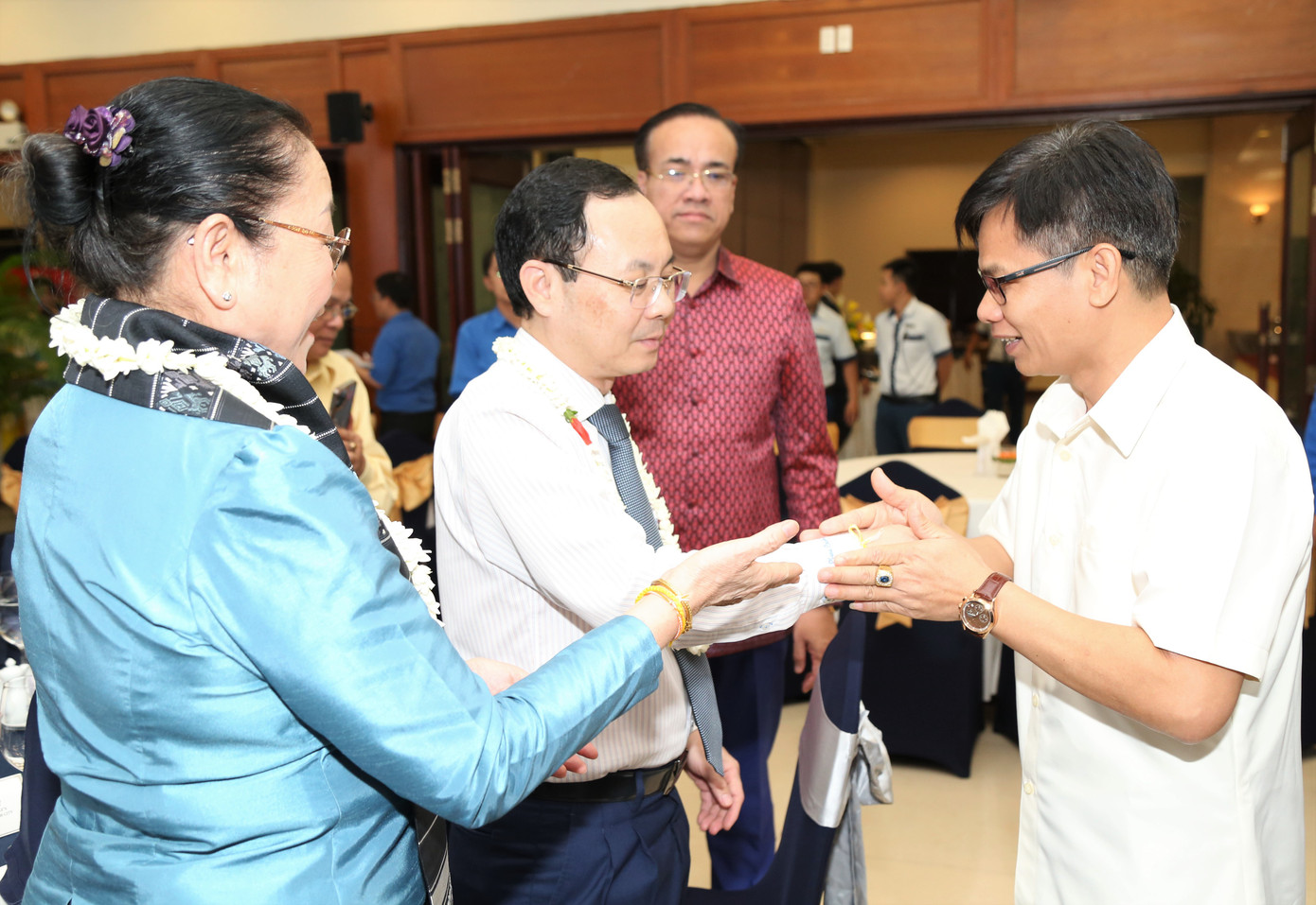 Đại diện Tổng Lãnh sự quán hai nước Lào, Campuchia thực hiện nghi thức truyền thống buộc chỉ cổ tay cho lãnh đạo TPHCM. Ảnh: Ngô Tùng