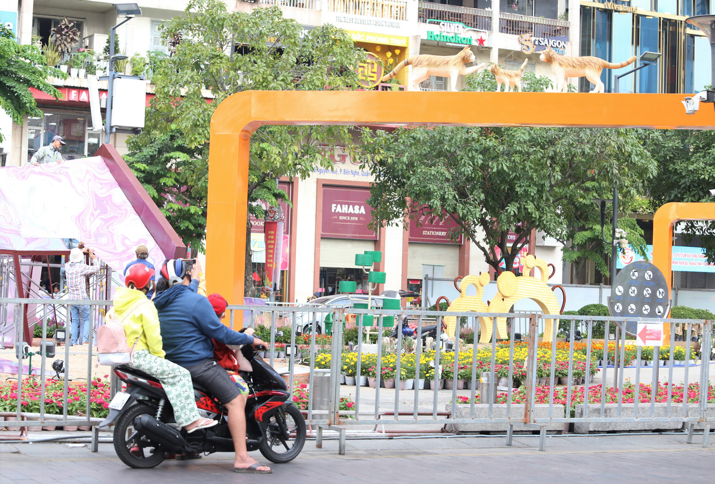 Một gia đình trẻ tranh thủ ghi hình không gian đường hoa khi đi ngang qua Phố đi bộ Nguyễn Huệ.