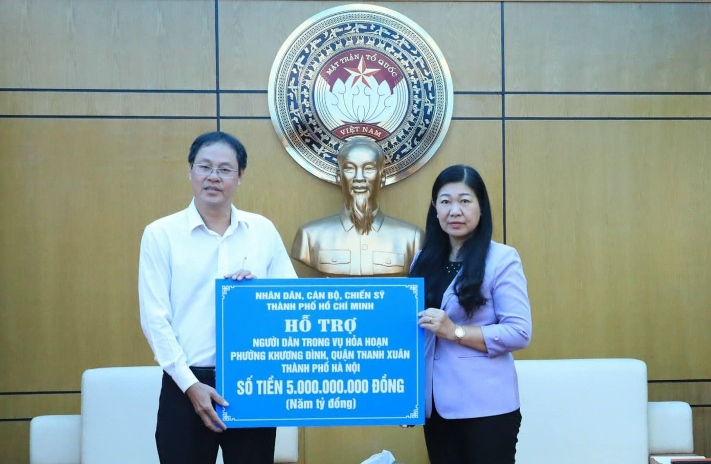 Ông Nguyễn Thành Trung trao bảng tượng trưng tặng người dân vụ hoả hoạn ở phường Khương Đình số tiền 5 tỷ đồng. Ảnh: MTTQ TPHCM