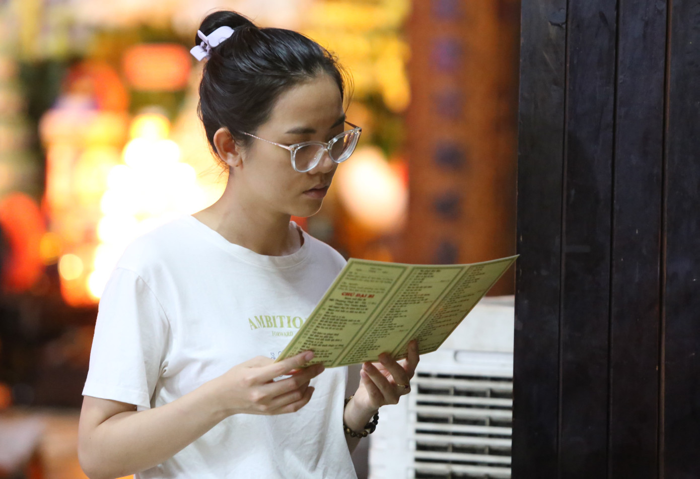 Một bạn trẻ chú tâm tìm hiểu kinh pháp tại khuôn viên nhà chùa.