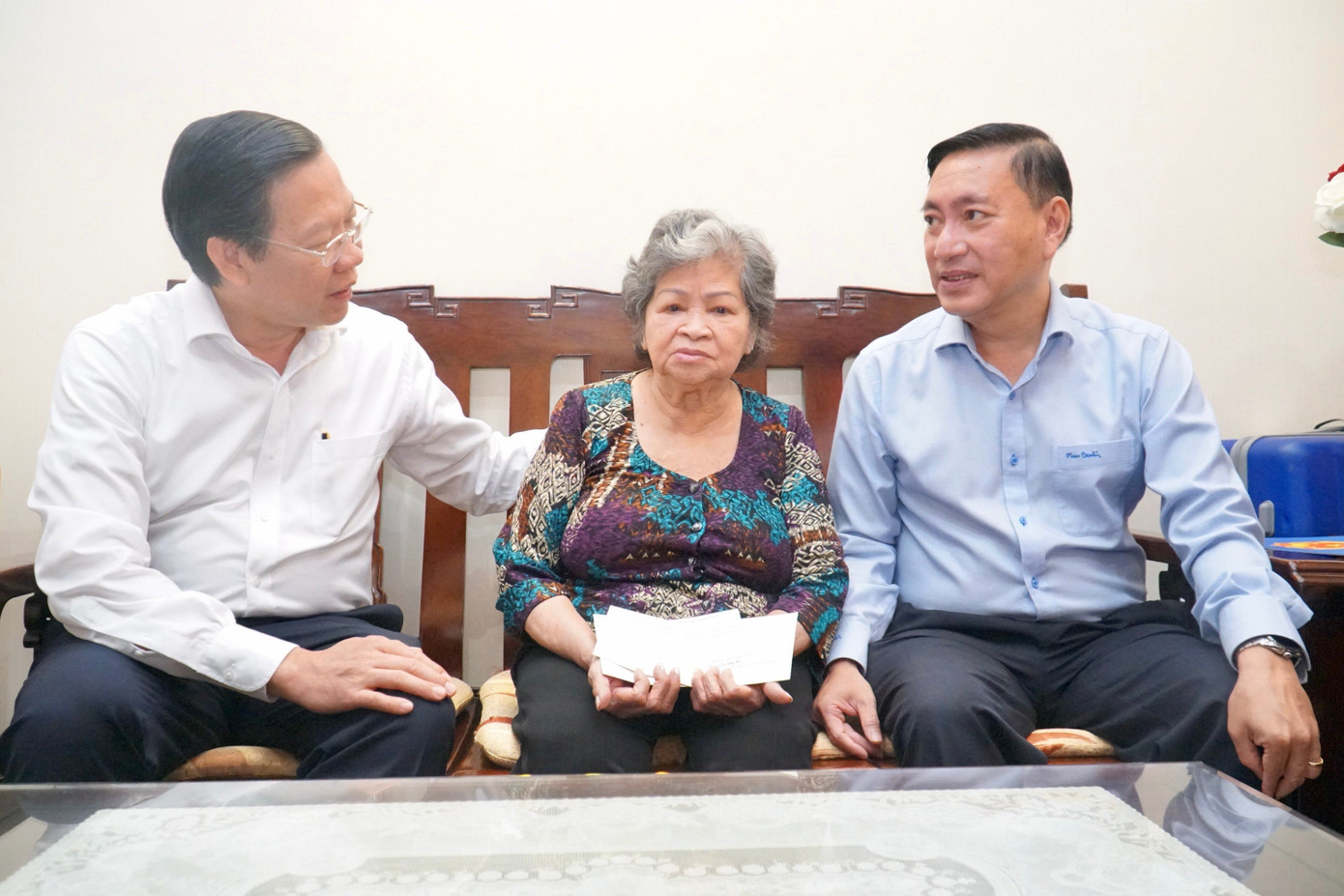 Chủ tịch UBND TPHCM Phan Văn Mãi (bìa trái) thăm hỏi, tặng quà tri ân Mẹ Việt Nam anh hùng Nguyễn Thị Bê (83 tuổi, ngụ ở phường 5, quận 3). Mẹ Bê có hai người con là liệt sĩ Bùi Văn Thành và Bùi Văn Cường. Do tuổi cao, sức yếu, mẹ Bê đi lại khó khăn. Mẹ được các con, cháu chăm lo phụng dưỡng. Ảnh: Bảo Phương.