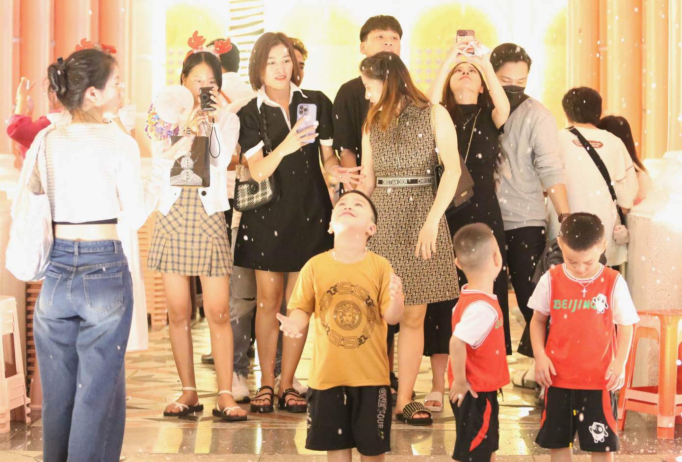 Các bạn trẻ hào hứng chụp ảnh lưu niệm trong khung cảnh tuyết rơi.