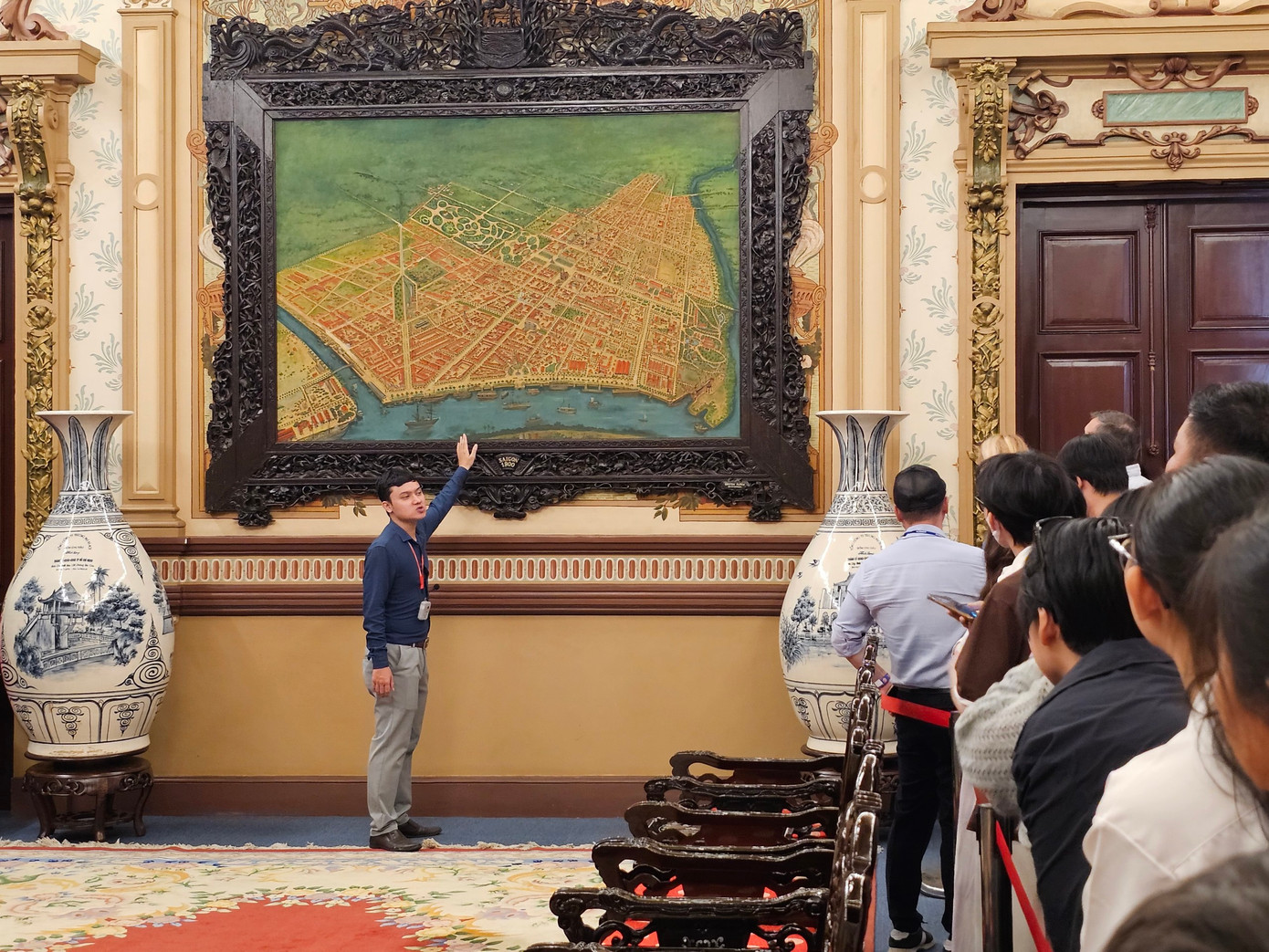 Hướng dẫn viên thuyết minh về tấm bản đồ thể hiện những công trình, di tích nằm xung quanh tòa nhà như: Dinh Thống Nhất, Thảo Cầm Viên Sài Gòn... Ngay bên cạnh là hai bình gốm Chu Đậu có in hình những thắng cảnh các vùng miền đất nước. Hướng dẫn viên thuyết minh về tấm bản đồ thể hiện những công trình, di tích nằm xung quanh tòa nhà như: Dinh Thống Nhất, Thảo Cầm Viên Sài Gòn... Ngay bên cạnh là hai bình gốm Chu Đậu có in hình những thắng cảnh các vùng miền đất nước.