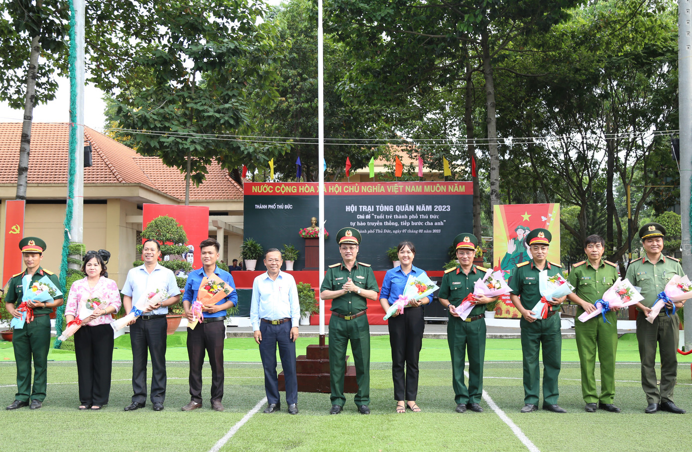 Trung tướng Nguyễn Văn Nam, Tư lệnh Bộ Tư lệnh TPHCM, Phó Chủ tịch thường trực Hội đồng Nghĩa vụ quân sự TPHCM và ông Nguyễn Hữu Hiệp, Bí thư Thành ủy Thủ Đức trao hoa cho các thành viên Ban tổ chức Hội trại tòng quân TP. Thủ Đức. Ảnh: Ngô Tùng