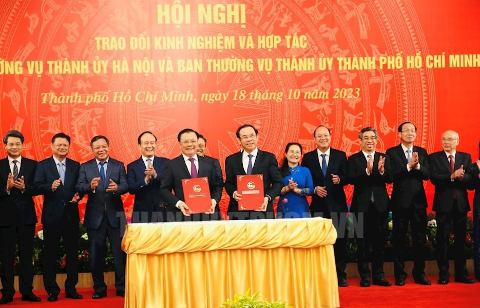Bí thư Thành uỷ Hà Nội Đinh Tiến Dũng (bên trái) cùng Bí thư Thành uỷ TPHCM Nguyễn Văn Nên (bên phải) ký kết các nội dung hợp tác. Ảnh: Thành uỷ TPHCM. Bí thư Thành uỷ Hà Nội Đinh Tiến Dũng (bên trái) cùng Bí thư Thành uỷ TPHCM Nguyễn Văn Nên (bên phải) ký kết các nội dung hợp tác. Ảnh: Thành uỷ TPHCM.