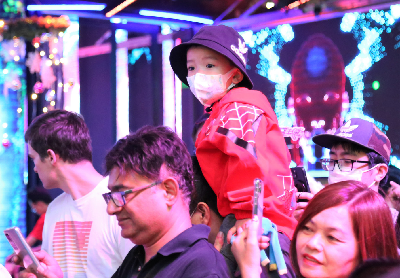 Em bé được người thân công kênh lên vai để dễ di chuyển.